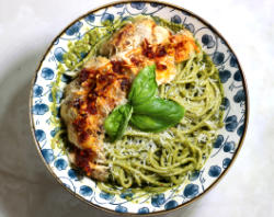 Photo of Chili Crisp Pesto Pasta in a white and blue decorative ramen bowl. It is a generous serving of pasta.