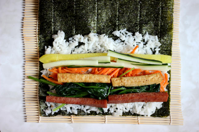 Gimpab ingredients on rice and seaweed right before it gets rolled up.