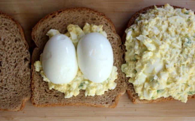 Photo shows how to build egg salad sandwiches with a whole egg in the middle. Step 4 gives more detail.