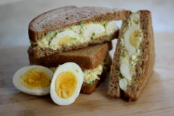 Picture of egg salad sandwiches and a hard boiled egg. 